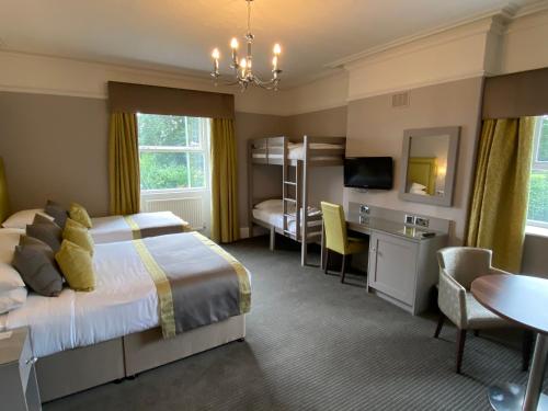 佩尼斯通Cubley Hall的酒店客房带一张床铺、一张书桌和一间卧室