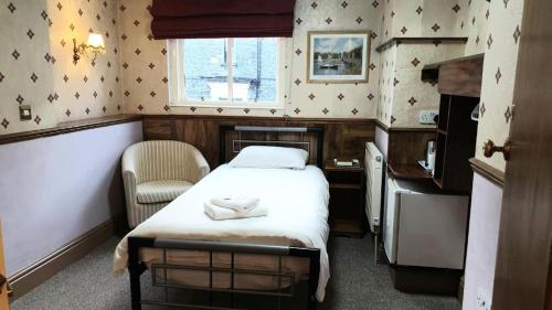 温德米尔温德米尔湖旅馆的小房间设有一张床和一把椅子