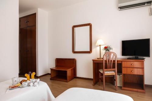 邦巴拉尔指挥官酒店的客房设有一张床、一张书桌和电视