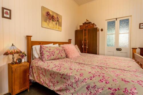 史丹霍普迪伦斯乡村民宿的一间卧室配有一张带粉红色棉被的床