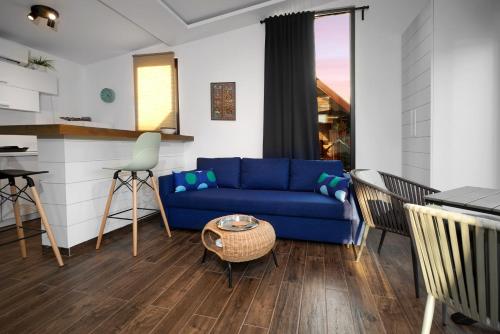 贝尔格莱德Beach House Belgrade的一间带蓝色沙发的客厅和一间厨房
