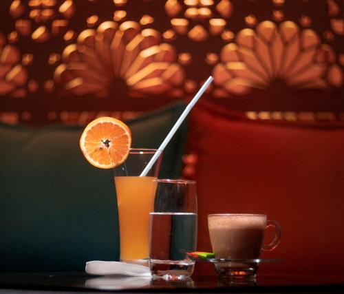 努瓦克肖特Urban Hotel Nouakchott的坐在桌子上的一杯橙汁