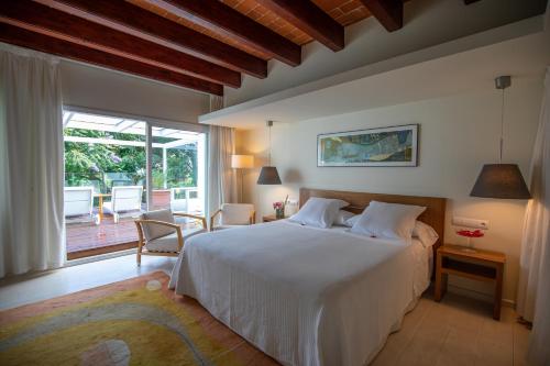 莱斯卡瑟斯-达尔卡纳坦卡特德科多纽酒店的卧室设有白色的床和大窗户