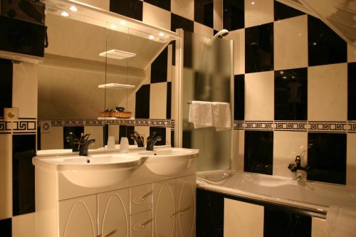 弗朗科尔尚Hotel Le Relais de Pommard的浴室设有2个水槽、浴缸和镜子