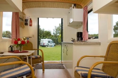泽尔赫姆Camping 't Bosch的厨房以及带桌椅的用餐室。
