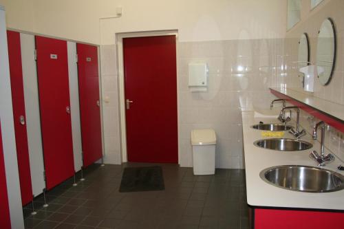 泽尔赫姆Camping 't Bosch的浴室设有两个盥洗盆和两个红色的门