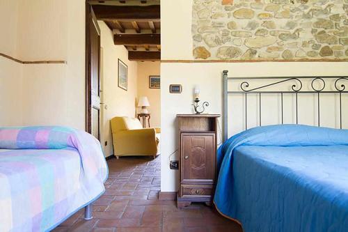安吉亚里Appartamenti con cucina nelle colline toscane的一间卧室配有两张床和椅子