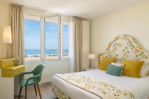 迪耶普Hôtel de la Plage的一间卧室设有一张床和一个海景窗户