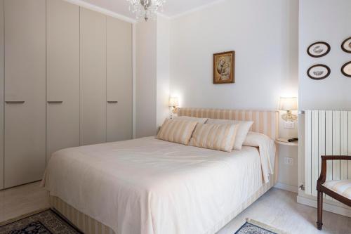 佩萨罗Casa del Teatro appartamento con splendida terrazza的白色卧室配有床和椅子