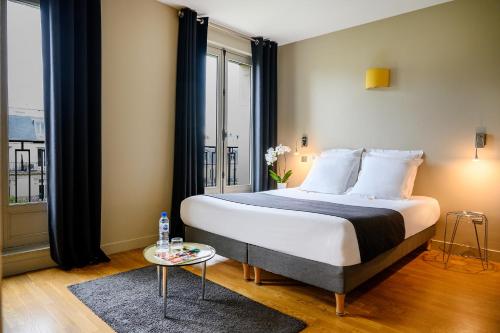巴黎赫尔沙尔香榭丽舍套房及酒店的一间卧室设有一张床和一个大窗户