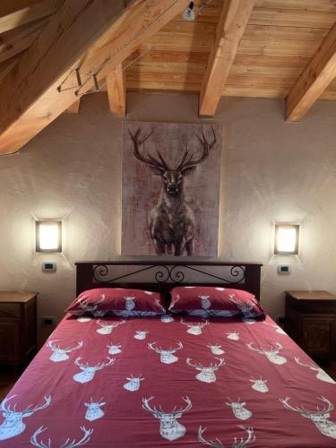 艾马维尔丹尼公寓的卧室配有一张挂着鹿画的床。