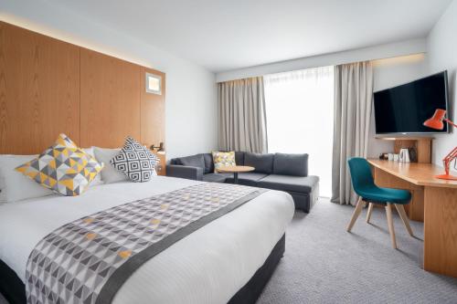 伯恩茅斯Holiday Inn Bournemouth, an IHG Hotel的酒店客房设有一张大床和一张书桌。