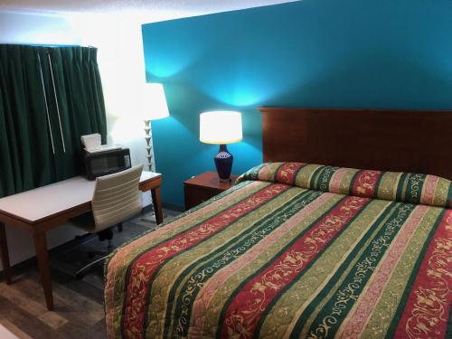 乔治敦Econo Lodge的酒店客房配有一张床、一张桌子和一把椅子。