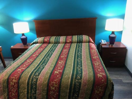 乔治敦Econo Lodge的一间卧室配有一张大床,桌子上放着两盏灯
