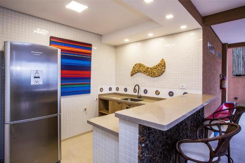 伊利亚贝拉Ilhabela Beach Residences的厨房配有不锈钢冰箱和台面