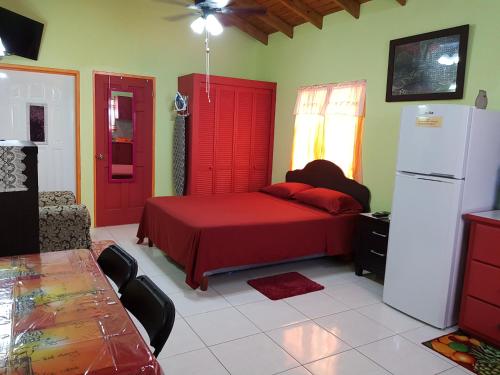 OsbournTequila Sunrise Antigua的一间卧室配有红色的床和冰箱