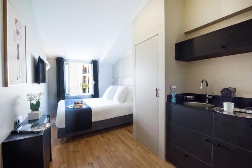 巴黎赫尔奇尔伊托勒套房酒店的卧室配有床和盥洗盆