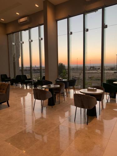 海米斯穆谢特قولدن سكوير طريق الرياض Golden Square Riyadh Road的餐厅设有桌椅和大窗户。