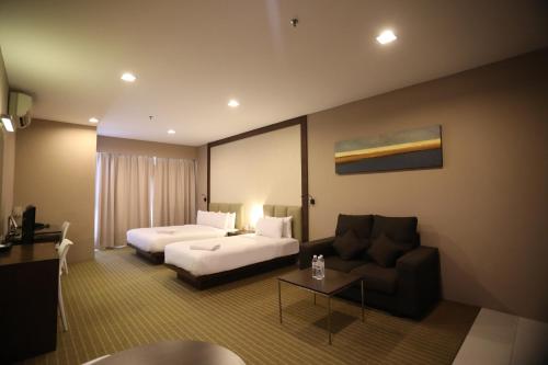 塞贝维Hotel Primera Suite - formally known as Tan Yaa Hotel Cyberjaya的酒店客房,配有床和沙发