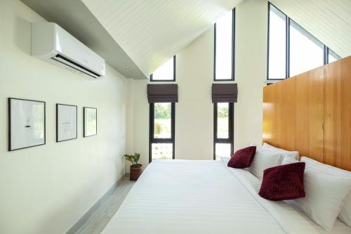 清莱Baan Ga-Cha的卧室配有带红色枕头的大型白色床