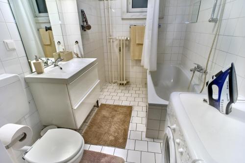 维也纳国家歌剧院小巷山林小屋的浴室配有卫生间、盥洗盆和浴缸。
