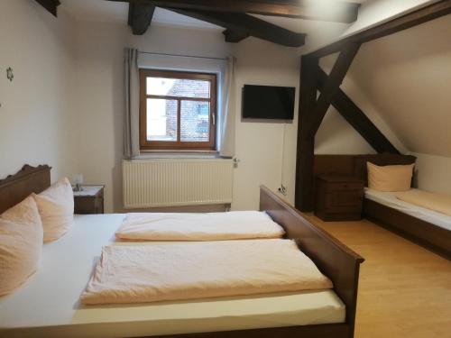 WiesentGaststätte Liebl的一间卧室设有两张床和窗户。