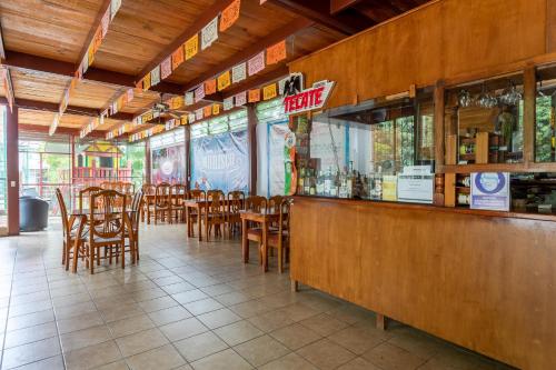 San Agustín EtlaHotel Paraje Casa Blanca的餐厅设有酒吧,配有木桌和椅子