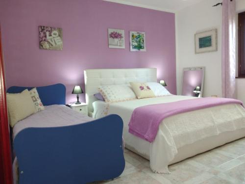 奥列纳Sole e Luna的一间卧室设有两张床和紫色的墙壁