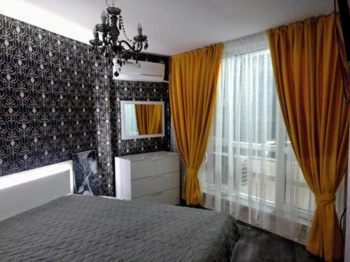 普罗夫迪夫Valentina GOLD apartment的一间卧室配有床、黄色窗帘和镜子