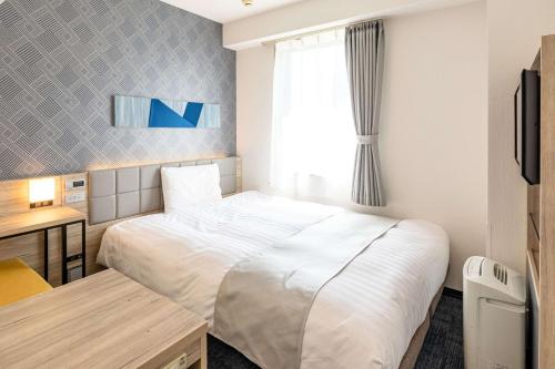广岛广岛大手町康福酒店的配有一张床和一张书桌的酒店客房