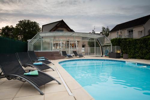 Le PêchereauLogis Hotel Restaurant L'Escapade的一座房子旁带躺椅的游泳池