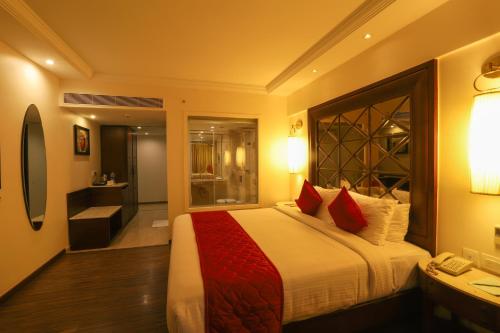 钦奈The Saibaba Hotel的一间卧室配有一张带红色枕头的大床