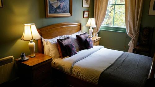 温彻斯特阿尔弗雷德国王酒店的一间卧室配有一张带枕头的床和两盏灯。