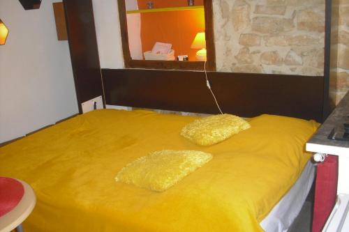 戈尔德La melonnière的一张黄色的床,上面有两个黄色枕头