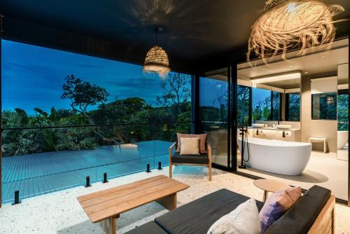 拜伦湾Ocean Suites Byron Bay的开放式客厅设有浴缸和大窗户