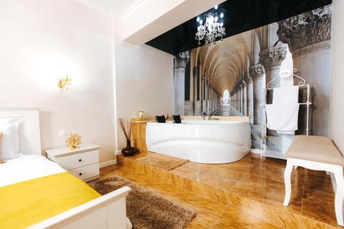 加拉茨Hotel Evianne Boutique的一间带白色浴缸和床的浴室