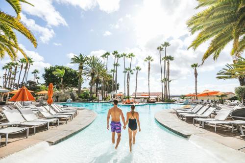 圣地亚哥San Diego Mission Bay Resort的两个人在度假村的游泳池里散步
