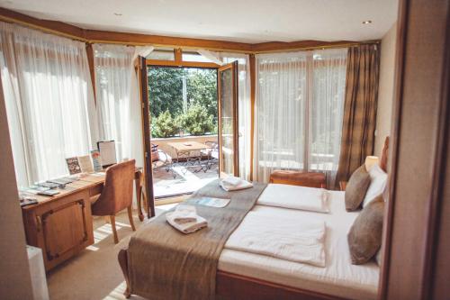 巴尼亚卢卡Provence rooms的一间卧室配有一张床、一张书桌和一个窗户。