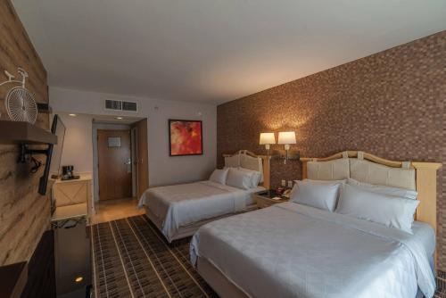 克雷塔罗Holiday Inn Queretaro Centro Historico, an IHG Hotel的酒店客房设有两张床和电视。