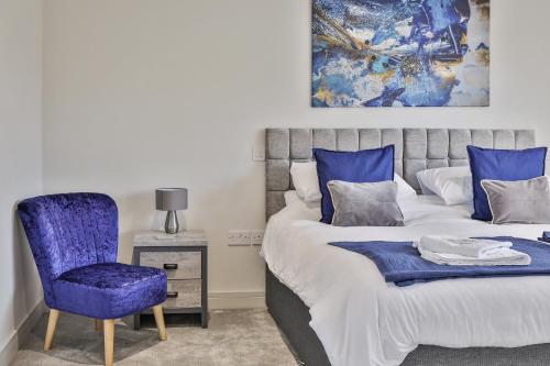 谢菲尔德Modern, Cosy & Convenient 3 bed 2 bath House WiFi Parking by Ark SA的一间卧室配有蓝色椅子和一张床