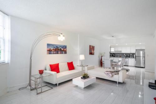 迈阿密海滩Sunny Isles Ocean Reserve Superb Condo Apartments的客厅配有白色家具和红色枕头。