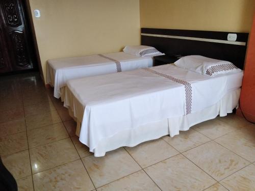 马瑙斯Hotel Saint Paul 01 Flat的两张睡床彼此相邻,位于一个房间里