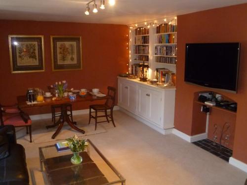 切尔滕纳姆Laurel House的客厅配有桌子和电视