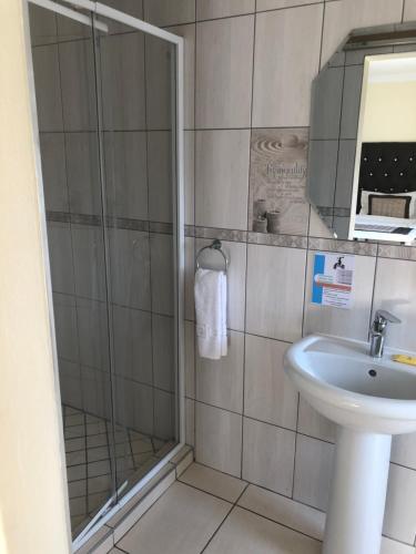肯普顿帕克OR坦博机场酒店的带淋浴和盥洗盆的浴室