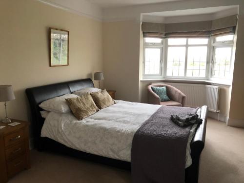 LowdhamGrange House Bed & Breakfast的一间卧室配有一张床、一把椅子和窗户。