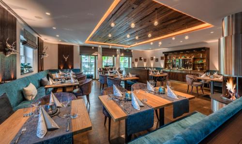 奥巴拉马高马克西米利安酒店的餐厅设有木桌和蓝色沙发。