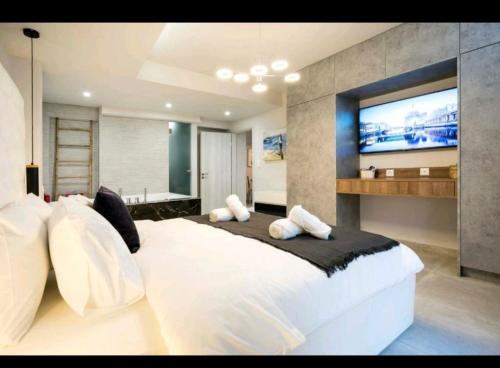 雅典DELUXE ROMANTIC JACUZZI的卧室配有一张大白色床和平面电视