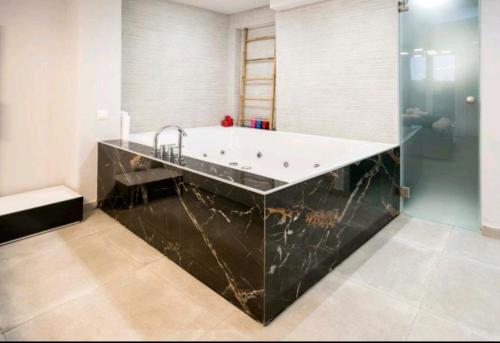 雅典DELUXE ROMANTIC JACUZZI的带浴缸和盥洗盆的浴室