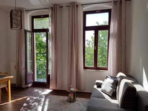 德累斯顿Stilvolle 1-Raum-Wohnung zentral, ruhig gelegen的带沙发和2扇窗户的客厅