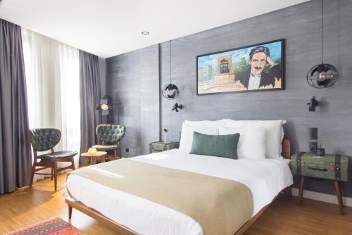 伊斯坦布尔诗歌酒店的酒店客房设有一张床,墙上挂有绘画作品